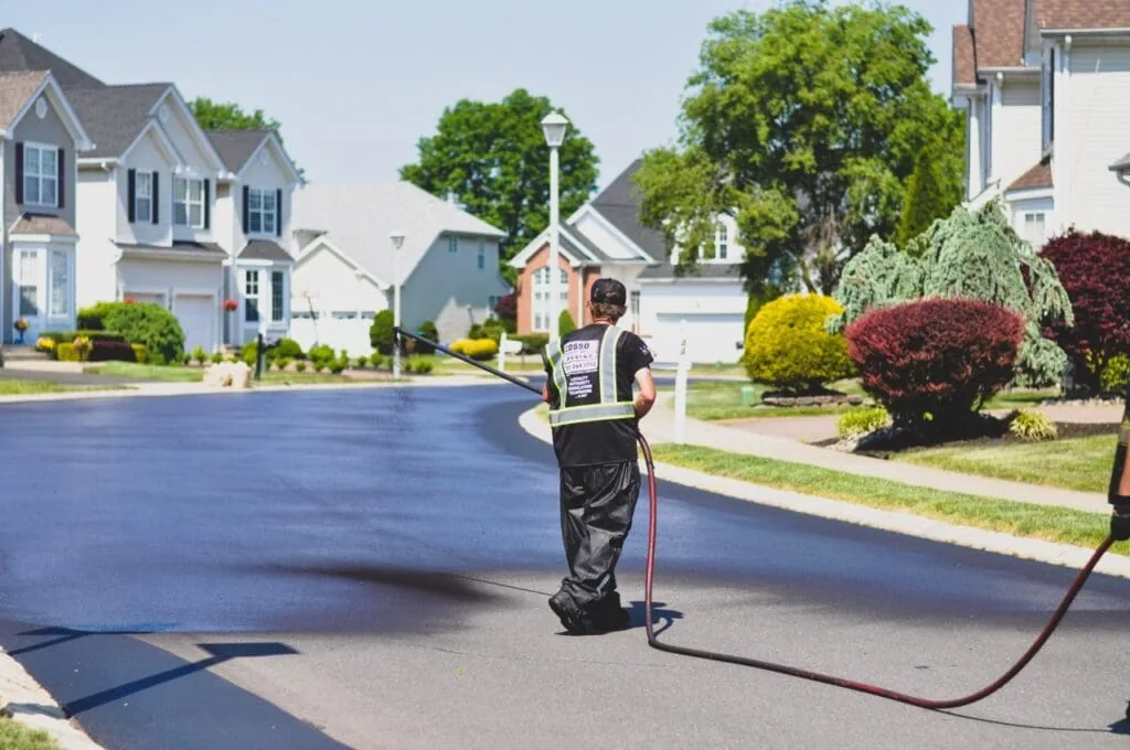 asphalt sealcoating service in progress on a residential street