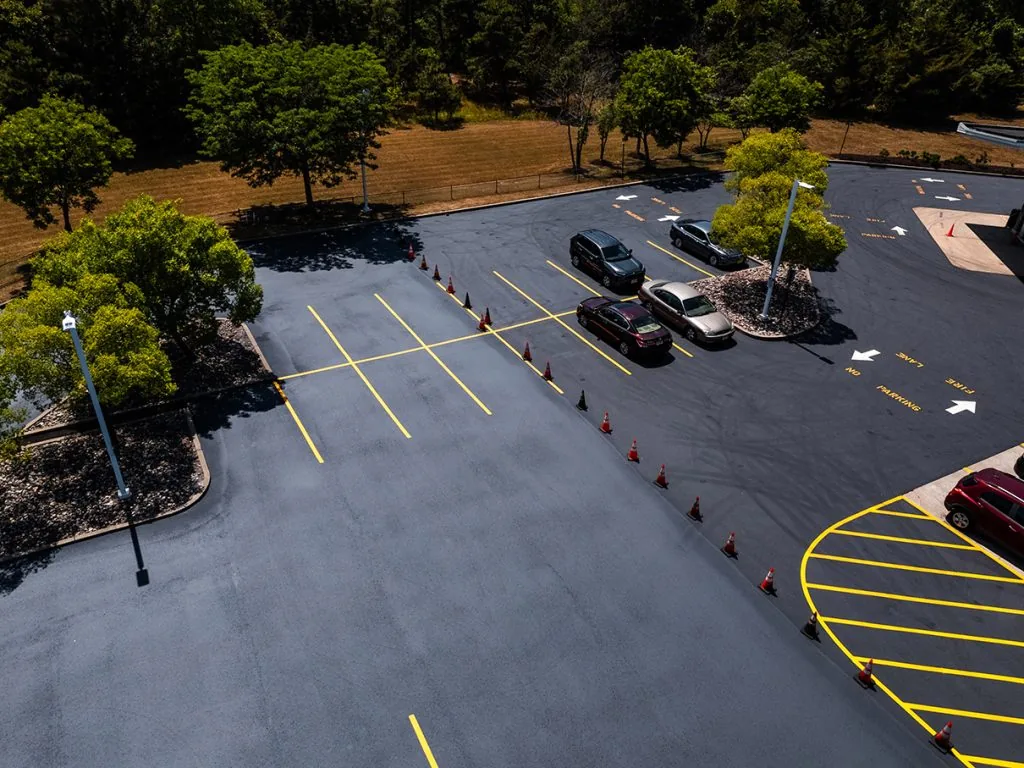 aerial view of a parking lot with fresh parking lot sealcoating and nicely paved blacktop