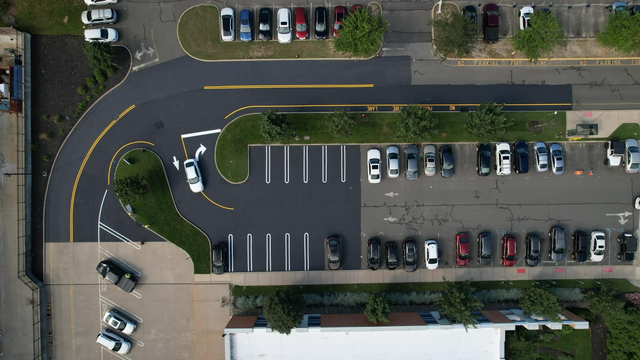 side by side comparison of before and after with parking lot milling, sealcoating and striping