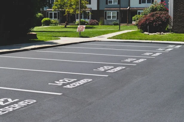 Resurfaced apartment parking lot with fresh white striping and numbered resident spaces